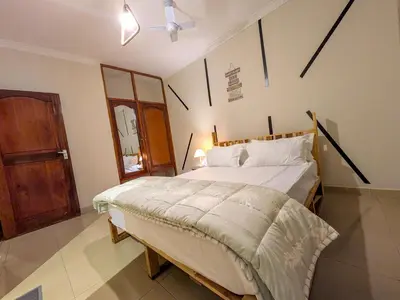a bedroom with a large bed and a wooden door at Joy Land Stay in Arusha