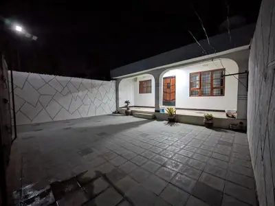 an empty parking lot with a white building with windows at Joy Land Stay in Arusha