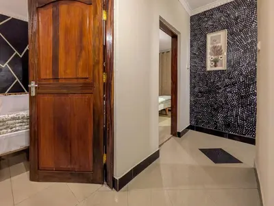 a room with a wooden door and a bedroom at Joy Land Stay in Arusha