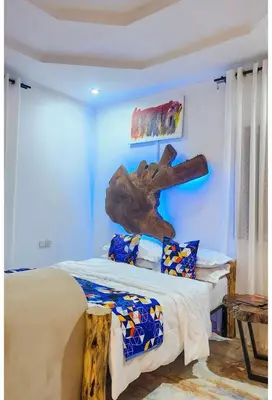 a bedroom with a bed with a wooden headboard at Sunset Quarters in Arusha