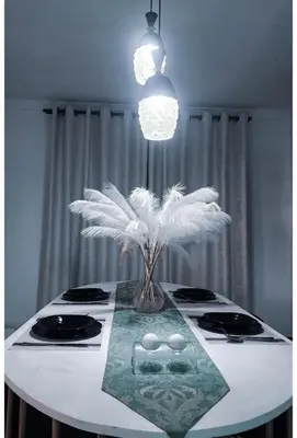 a table with a vase with white feathers on it at Sunset Quarters in Arusha