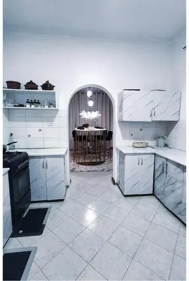 a kitchen with white cabinets and a table in the background at Sunset Quarters in Arusha