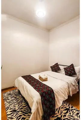 a bedroom with two beds and a rug at Sunset Quarters in Arusha