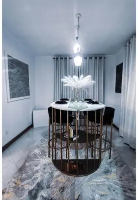 a dining room with a white table and chairs at Sunset Quarters in Arusha