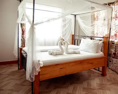 a bedroom with a canopy bed with two swans at Kitopua suites in Arusha
