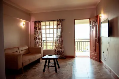 a living room with a couch and a table at Kitopua suites in Arusha