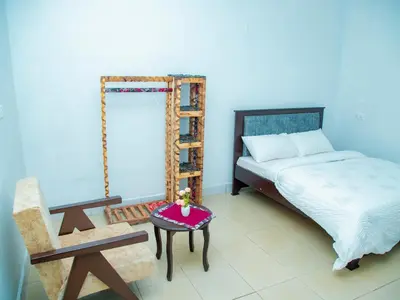 a bedroom with a bed and a ladder and a table at Serene Vacay Lodge Soweto in Moshi