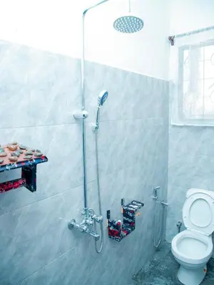 a bathroom with a shower and a toilet at Serene Vacay Lodge Soweto in Moshi