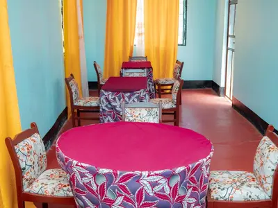 a room with tables and chairs with red table cloth at Serene Vacay Lodge Soweto in Moshi