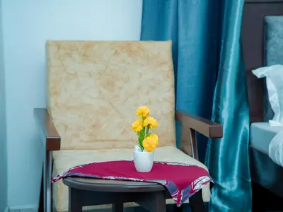 a vase with yellow flowers sitting on a chair at Serene Vacay Lodge Soweto in Moshi