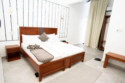 a bedroom with a bed with white sheets and pillows at Njiro Luxury Resort in Arusha