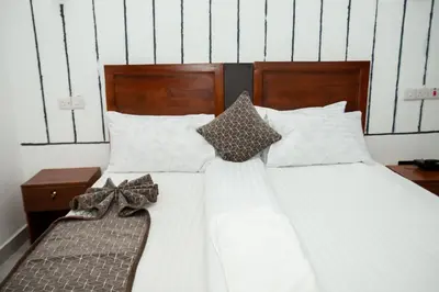 a bed with white sheets and bow ties on it at Njiro Luxury Resort in Arusha