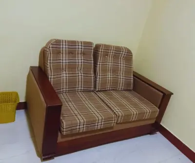 a brown chair sitting in a corner of a room at Moshi Roots Homestay in Msaranga