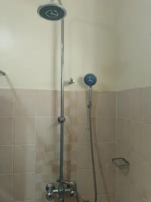 a shower with a shower head in a bathroom at Moshi Roots Homestay in Msaranga