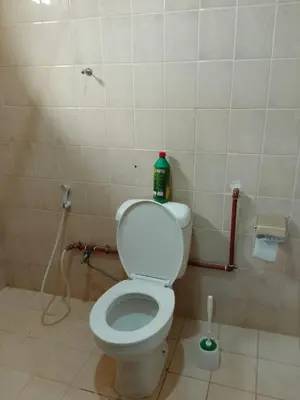 a bathroom with a toilet with a bottle on it at Moshi Roots Homestay in Msaranga