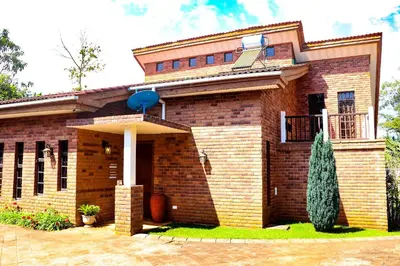 a brick house with a tree in front of it at Arcola Residence Machame
