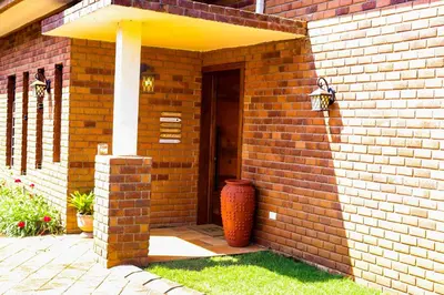 a brick building with a door and a vase at Arcola Residence Machame