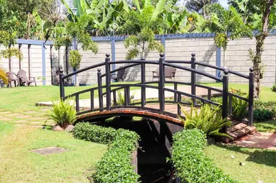 a small bridge over a small pond in a park at Arcola Residence Machame