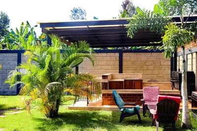 a patio with chairs and a table in a yard at Arcola Residence Machame
