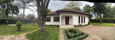 a small white house with a garden in front of it at Arusha Njiro B&B in Arusha