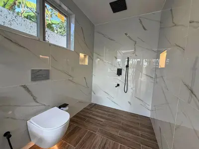 a white bathroom with a toilet and a shower at Modern Studio in Njiro, Arusha in Arusha