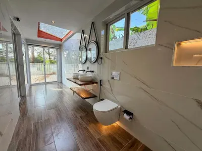 a bathroom with two sinks and two mirrors on the wall at Modern Studio in Njiro, Arusha in Arusha