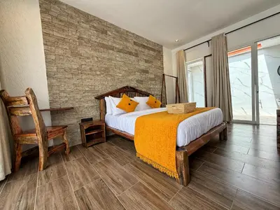 a bedroom with a bed and a brick wall at Modern Studio in Njiro, Arusha in Arusha