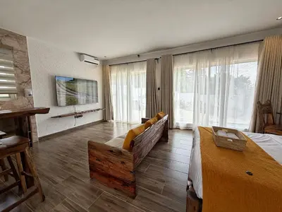 a large room with a bed and a couch andwindows at Modern Studio in Njiro, Arusha in Arusha