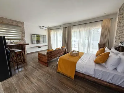 a bedroom with a large bed and a table and chairs at Modern Studio in Njiro, Arusha in Arusha