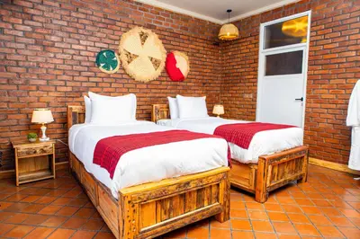 two beds in a room with a brick wall at Zondela House in Nkoanrua