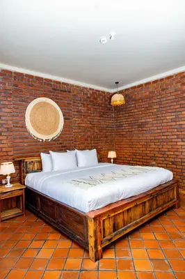 a bedroom with a large bed in a brick wall at Zondela House in Nkoanrua