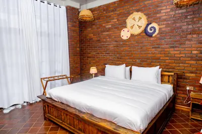 a bedroom with a large bed with a brick wall at Zondela House in Nkoanrua