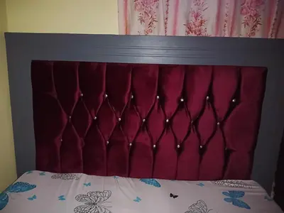 a bed with a red headboard with a white comforter at Karibu Neema Homestay and Breakfast in Nkoanrua