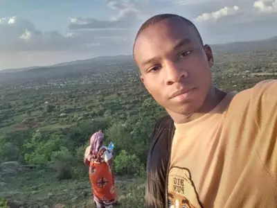 a young man standing on top of a hill at Karibu Neema Homestay and Breakfast in Nkoanrua