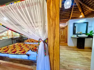 a bedroom with a bed with a mosquito net at Njiapanda Tented Lodge & Safari in Karatu
