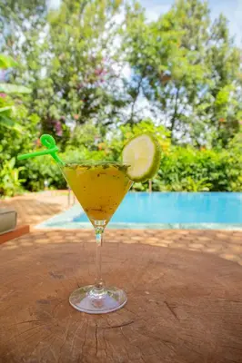 a drink with a lime in a glass on a table at Njiapanda Tented Lodge & Safari in Karatu