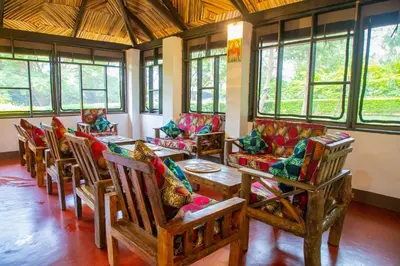 a room with many chairs and tables and windows at Njiapanda Tented Lodge & Safari in Karatu