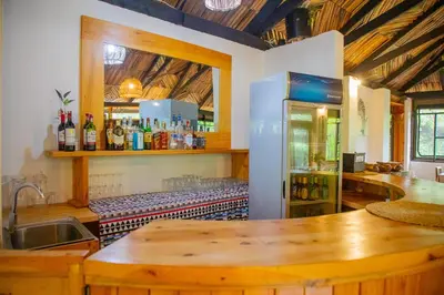 a kitchen with a counter and a refrigerator with bottles at Njiapanda Tented Lodge & Safari in Karatu