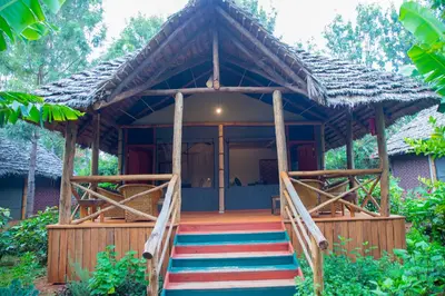 a wooden house with a staircase leading to it at Njiapanda Tented Lodge & Safari in Karatu