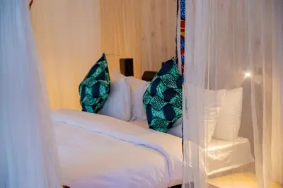 a bedroom with a bed with two pillows on it at Njiapanda Tented Lodge & Safari in Karatu