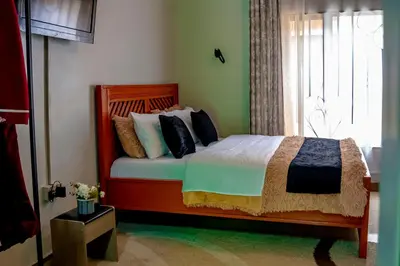 a bedroom with a bed and a window at Subira Home in Arusha
