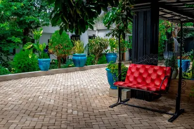 a red chair sitting on a brick patio with potted plants at Subira Home in Arusha