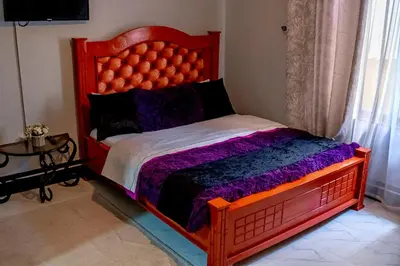 a bedroom with a large bed with a red headboard at Subira Home in Arusha