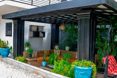 a pergola with plants in pots on a patio at Subira Home in Arusha
