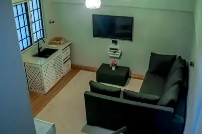 a living room with a couch and a tv at Subira Home in Arusha