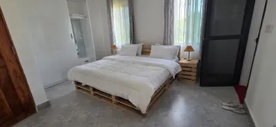a bedroom with a large bed with white sheets and pillows at Ruby Cozy Home's in Arusha