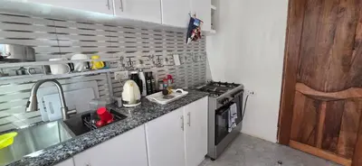 a small kitchen with a sink and a stove at Ruby Cozy Home's in Arusha