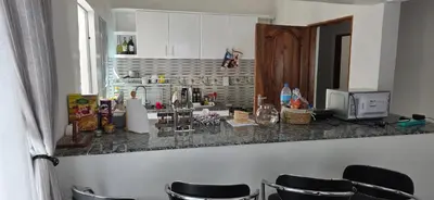 a kitchen with a counter with black stools at Ruby Cozy Home's in Arusha