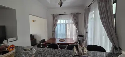 a dining room with a table and chairs and a window at Ruby Cozy Home's in Arusha