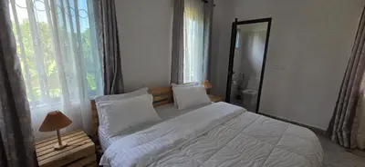 a bedroom with a large bed and a large window at Ruby Cozy Home's in Arusha